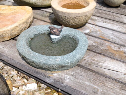 Vogeltränke aus grünlichem Granit mit Bronzevogel