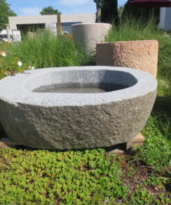 Granitbrunnen aus graunem Granit. Der Brunnen stammt aus Bayern, es handelt sich um einen bayrischen Granit