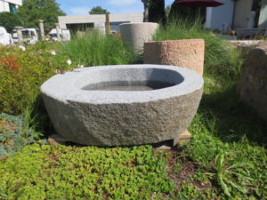 Granitbrunnen aus graunem Granit. Der Brunnen stammt aus Bayern, es handelt sich um einen bayrischen Granit