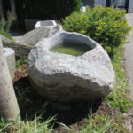 Findlingsbrunnen groß aus rötlich-grauem Granit