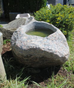 Findlingsbrunnen groß aus rötlich-grauem Granit