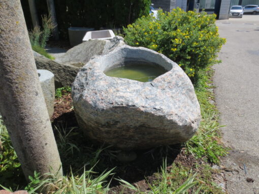 Findlingsbrunnen groß aus rötlich-grauem Granit