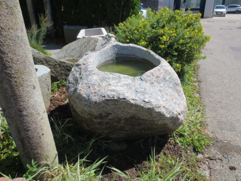 Findlingsbrunnen groß aus rötlich-grauem Granit