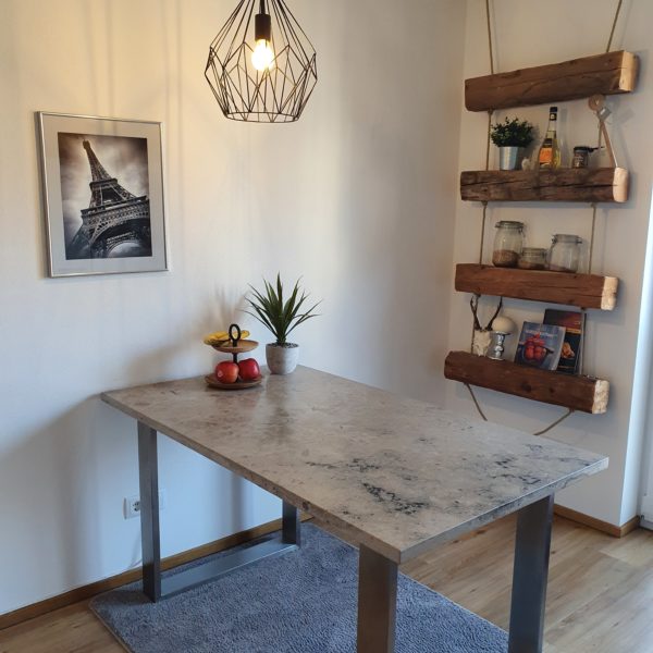 Tisch aus hochwertigem Naturstein mit eleganten Edelstahlfüßen