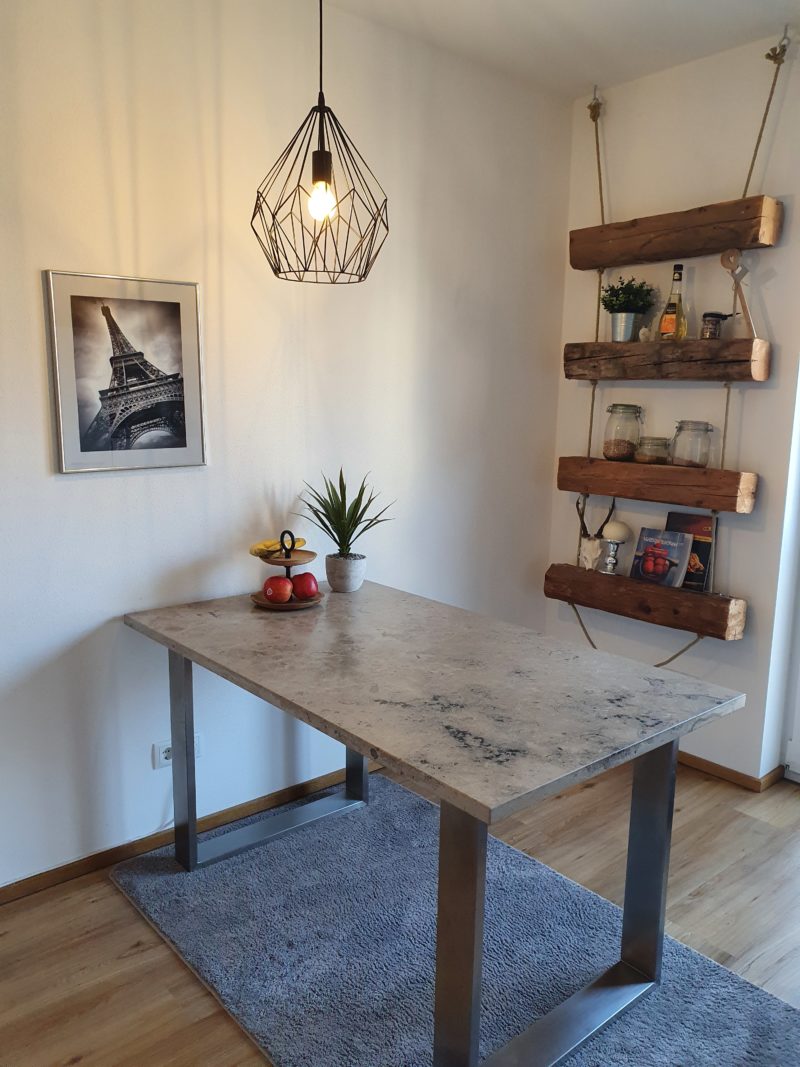 Tisch aus hochwertigem Naturstein mit eleganten Edelstahlfüßen