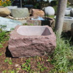 Findlingsbrunnen aus rotem Granit